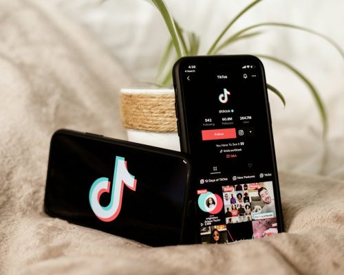 a couple of cell phones sitting on top of a bed