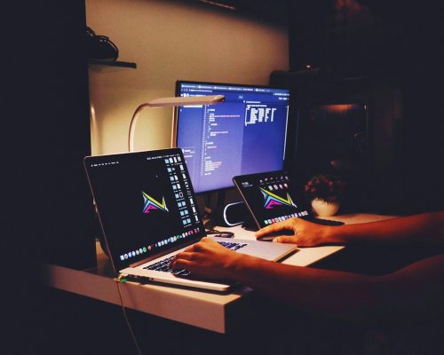 woman in black tank top sitting in front of computer