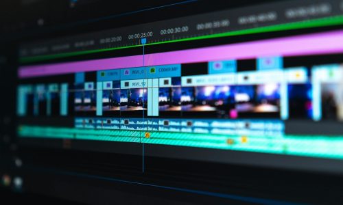 A video editing timeline with blue and purple clips on a dark screen