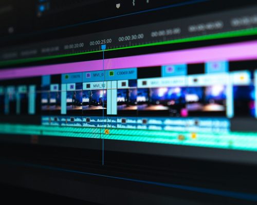 A video editing timeline with blue and purple clips on a dark screen