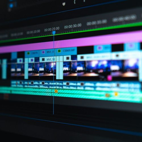 A video editing timeline with blue and purple clips on a dark screen